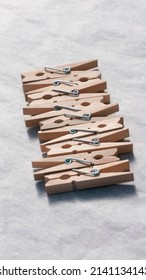 Wooden clothes pegs on white paper