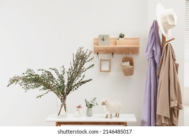 Wooden clothes rack and key holder on white wall in hallway - Powered by Shutterstock