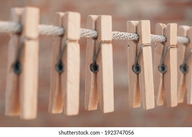 Wooden clothespins on a rope. Selective focus on one clothespin
