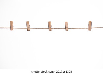 wooden clothespins on a rope on a white background, mock-up for design, copy space, rustic vintage style, clothesline for drying clothes with clothespins - Powered by Shutterstock