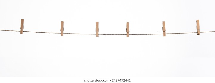 wooden clothespins on a rope on a white background isolate - Powered by Shutterstock