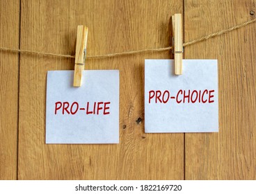 Wooden clothespins with white sheets of paper. Text 'pro-life, pro-choice'. Beautiful wooden background. Female right on abortion concept, copy space. - Shutterstock ID 1822169720