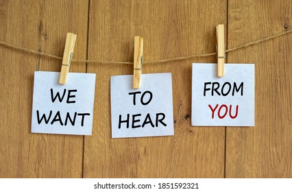 Wooden clothespins with white sheets of paper. Text 'we want to hear from you'. Beautiful wooden background. Business concept, copy space.