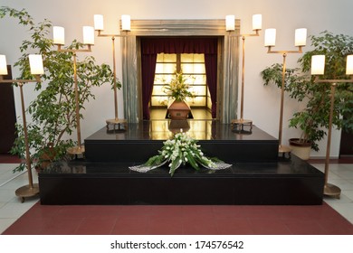 Wooden Coffin With Funeral Flowers In Crematorium