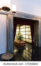 Wooden Coffin With Funeral Flowers In Crematorium