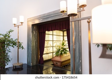 Wooden Coffin With Funeral Flowers In Crematorium