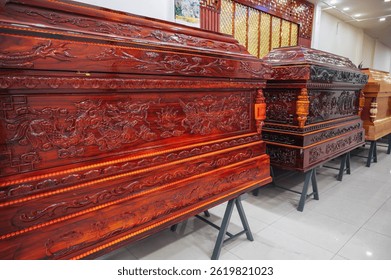 wooden coffins with a traditional Asian ornament pattern in a store in a funeral home in Asia in Vietnam