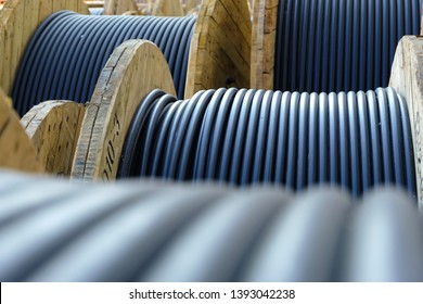Wooden Coils Of Electric Cable Outdoor. High and low voltage cables in the storage. - Shutterstock ID 1393042238