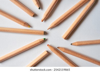 Wooden colored pencils scattered messy on white background. Minimalist art supplies concept, perfect for creative or educational themes. - Powered by Shutterstock