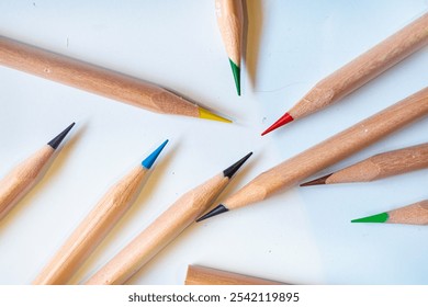 Wooden colored pencils scattered messy on white background. Minimalist art supplies concept, perfect for creative or educational themes. - Powered by Shutterstock