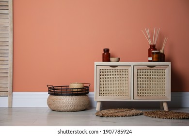 Wooden Commode Near Coral Wall In Room. Interior Design