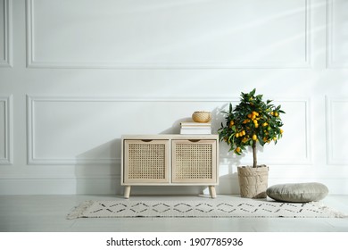 Wooden commode near white wall in room. Interior design - Shutterstock ID 1907785936