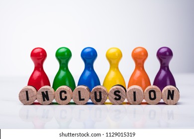 Wooden Cork With Inclusion Text In Front Of Multi Colored Pawn On Reflective Background