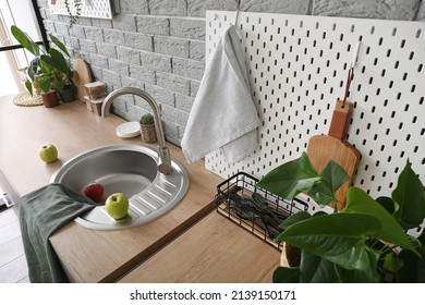 Wooden Counter And Pegboard With Kitchen Utensils Near Grey Brick Wall