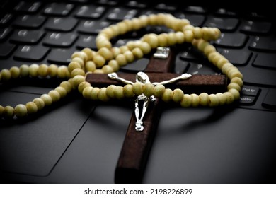 Wooden Cross Bead Necklace On Notebook Keyboard, Soft And Selective Focus On Bead Cross Necklace.