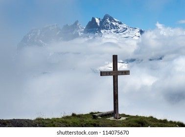 wooden cross in the clouds on a background of snowy peaks in the Swiss Alps - Powered by Shutterstock