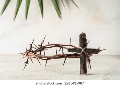 Wooden cross with crown of thorns on light background. Good Friday concept - Shutterstock ID 2265435987