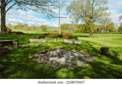 Wooden Cross And Fireplace. Gathering Place For Outdoor Recreation, Latvia. Green Landscape