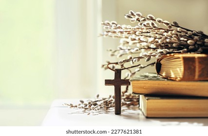 wooden cross, old biblical books and willow twigs close up on table, abstract light background. Orthodox palm Sunday, Easter holiday. Symbol of Christianity, Lent, Faith in God, Church. copy space - Shutterstock ID 2277621381
