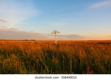 Wooden Cross On A Field Of Flowers (clover) During Sunset