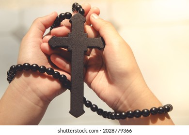 Wooden Cross On Praying Hands With Outdoor Background. International Prayer Day.Easter And Good Friday Concept.