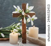 Wooden cross, snowdrops flowers and candles on table, abstract background. Religious church holiday.