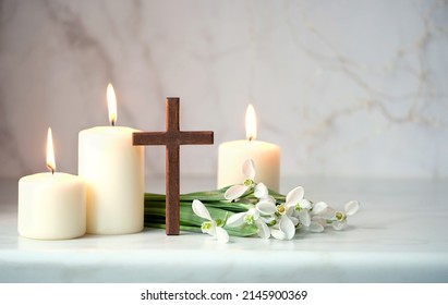 Wooden cross, snowdrops flowers and candles on table, blurred abstract background. Religious church holiday. symbol of faith in God, Christianity Feast, Easter, Palm Sunday, Lent - Shutterstock ID 2145900369
