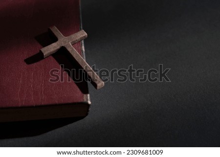 Wooden crucifix cross on a leather cover bible. Top view, copy space.