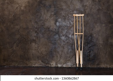 Wooden Crutches On The White Wal.