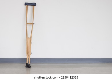 Wooden Crutches On White Wall.