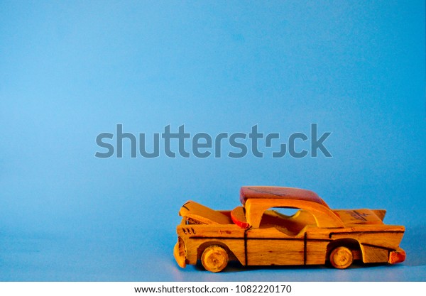 Wooden cuban toy\
car in light blue\
background