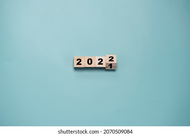 Wooden cube block flipping from 2021 to 2022 on blue background , preparation for merry Christmas and happy new year and 3d rendering concept.