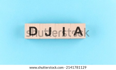 Wooden cube block with text DJIA on blue background