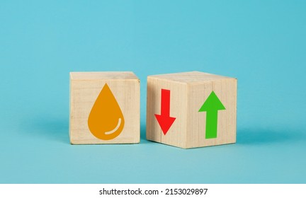 Wooden cube change UP arrow and Down arrow and oil symbol on blue background. Oil with arrow up. Falling or rising oil prices concept with turning wood cube with red and green arrow symbol