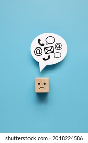 A wooden cube with a drawing of a sad face and his thoughts about work. A symbol of a lot of work for a person - Shutterstock ID 2018224586