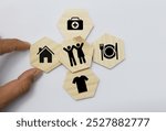 wooden cube with icons of food, Clothing, housing, medical bag, four basic human needs concepts. The Four Basic Material Needs of the Human Being.