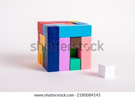 Wooden cube from multicolored blocks with one missing element. Construction last step concept. Kids game for logical thinking development. High quality photo