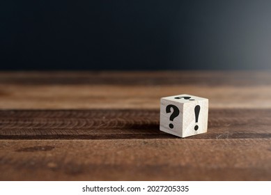 Wooden cube with question mark and exclamation point on wooden table. Concept of uncertainty, faq and questions and answers - Shutterstock ID 2027205335
