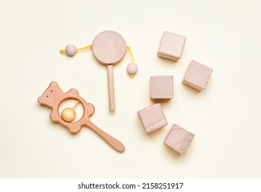 Wooden cubes with baby rattles on white background