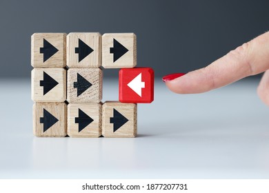 Wooden Cubes With Black Arrows And One Red One. Individual Approach In Business Concept