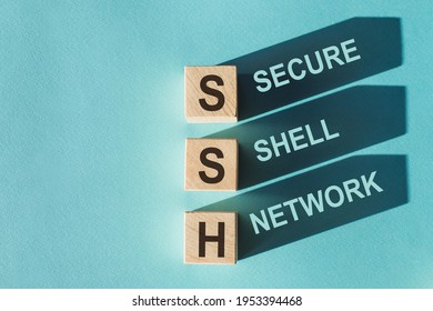 Wooden Cubes Building Word SSH - (abbreviation Secure Shell Network) On Light Blue Background.