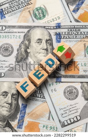 Wooden cubes with FED and up-down arrows over 100 usd. Fed rate hike concept to curb inflation