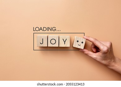 Wooden cubes in the form of a loading battery and the inscription: joy. A symbol of joy in life