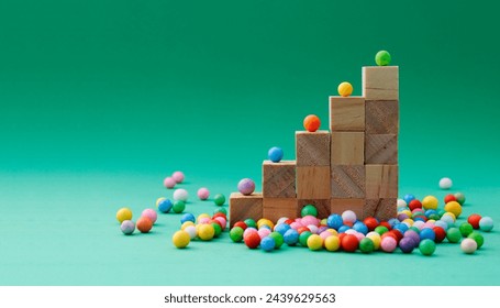 Wooden cubes forming a staircase with a sphere of a different color on each step and others concentrated at its base waiting to ascend