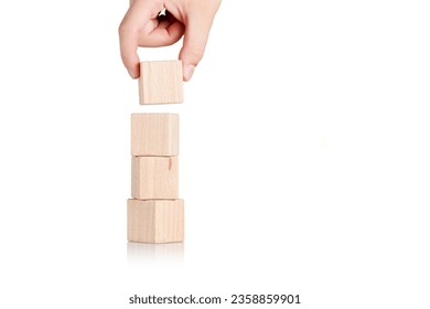 wooden cubes with hand on isolate white background close-up - Shutterstock ID 2358859901