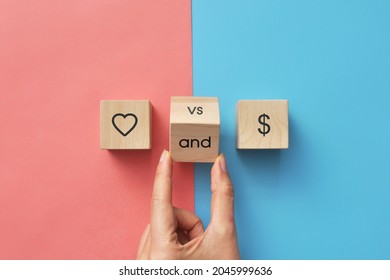 Wooden Cubes With The Image Of A Dollar And A Heart. Materialism And Spirituality Or Money Versus Love