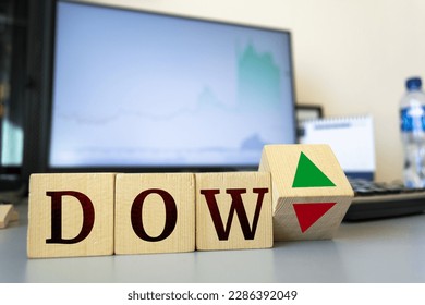 Wooden cubes with the inscription Dow Jones Index and a cube symbolizing the rise and fall of financial markets.