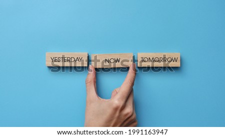 Wooden cubes with inscriptions: yesterday, tomorrow, now. A person's choice of the present moment