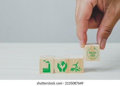 Wooden Cubes With Net Zero And Carbon Neutral Green Factory Icon Symbol Background And Copy Space.