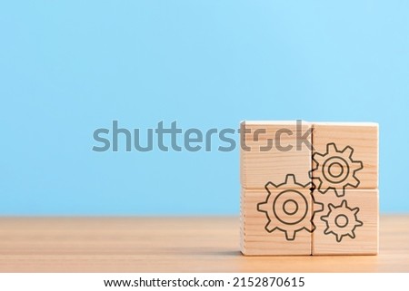 Wooden cubes on blue background with icon of settings seo setting cogwheels configuration gear, concept
